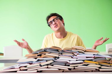 Sınavdan önce okumak için çok fazla kitabı olan öğrenci