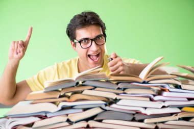 Sınavdan önce okumak için çok fazla kitabı olan öğrenci