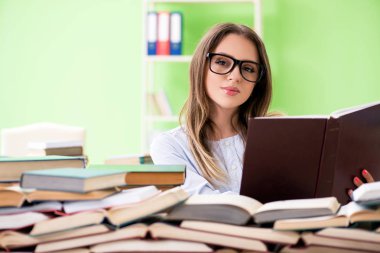 Sınavlara bir sürü kitapla hazırlanan genç kız öğrenci. 