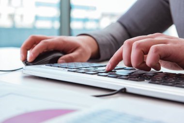 Raporlarla klavyede çalışan finans uzmanı