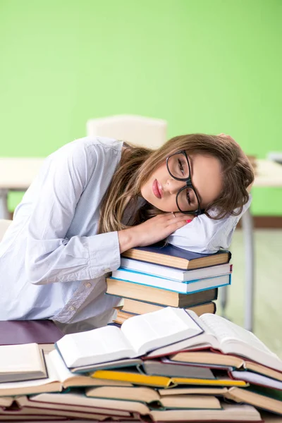 Jonge vrouwelijke student bereidt zich voor op examens met veel boeken — Stockfoto