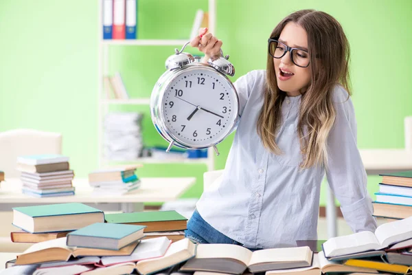 Giovane studentessa che si prepara per gli esami con molti libri in tempo — Foto Stock