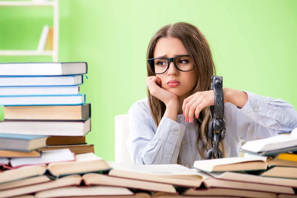 Jovem estudante acorrentada à mesa e se preparando para exames — Fotografia de Stock