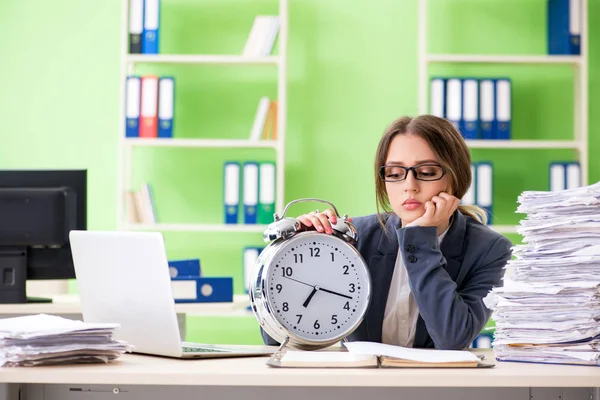 Jonge vrouwelijke werknemer zeer druk met lopende papierwerk in de tijd m — Stockfoto