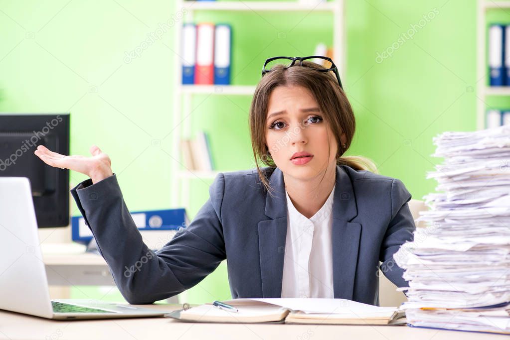 Young female employee very busy with ongoing paperwork