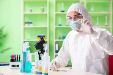 Laboratuvarda yeni bir deney üzerinde çalışan kimyager.