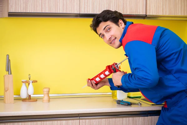 Reparador trabalhando na cozinha — Fotografia de Stock