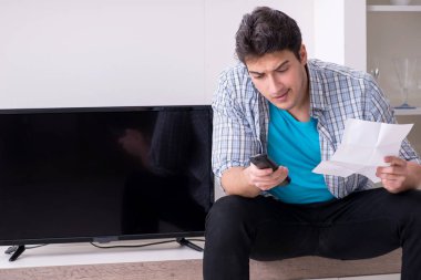 Bozuk televizyonu tamir etmeye çalışan adam