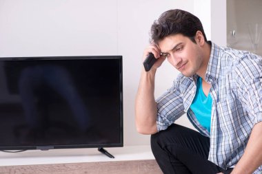 Bozuk televizyonu tamir etmeye çalışan adam