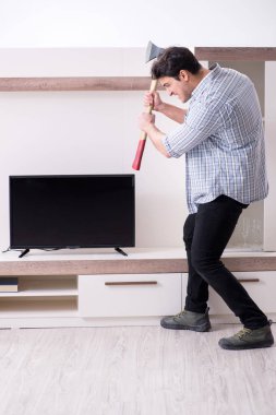 Bozuk televizyonu tamir etmeye çalışan adam