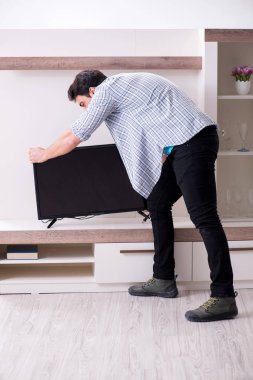 Bozuk televizyonu tamir etmeye çalışan adam