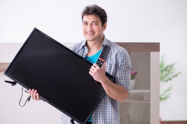 Bozuk televizyonu tamir etmeye çalışan adam