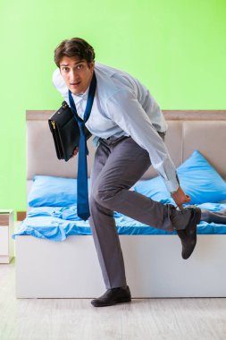 İşçi yatak odasında işe geç kalıyor. 