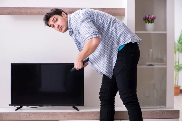 Man trying to fix broken tv — Stock Photo, Image