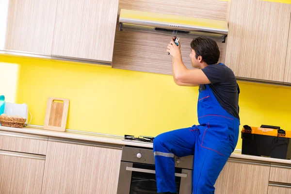 Jovem empreiteiro de serviços montagem de mobiliário de cozinha — Fotografia de Stock