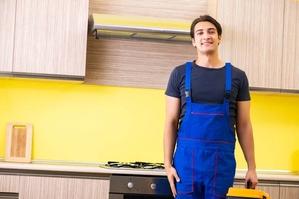 Young service contractor assembling kitchen furniture