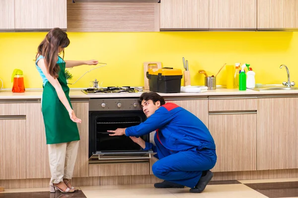 Mulher com empreiteiro na cozinha discutindo reparação — Fotografia de Stock