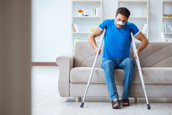 Homme blessé avec des béquilles récupérant à la maison — Photo