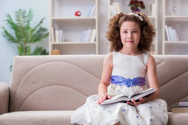 Pequeña chica bonita leyendo libros en casa — Foto de Stock