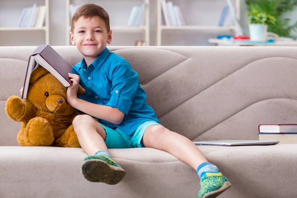Liten pojke läser böcker hemma — Stockfoto