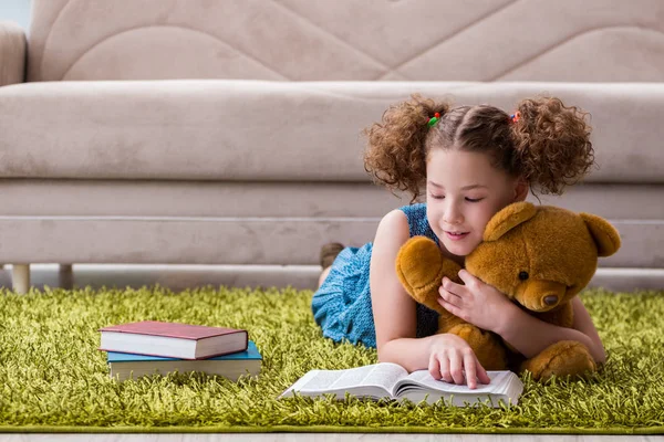 Pequena menina bonita ler livros em casa — Fotografia de Stock