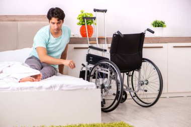 Genç yakışıklı engelli adam evde iyileşiyor. 
