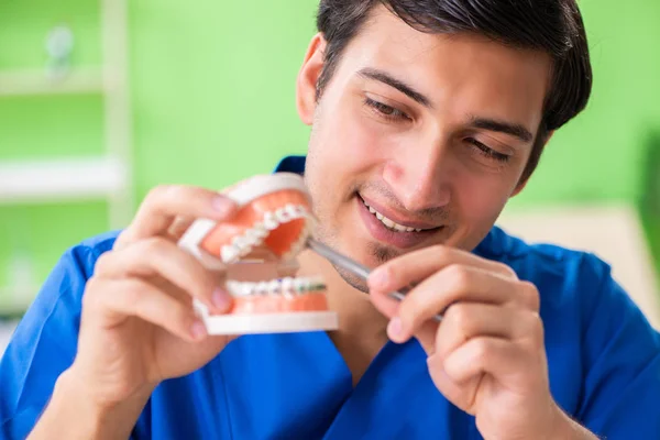 Erkek dişçi yeni diş implantı üzerinde çalışıyor. — Stok fotoğraf