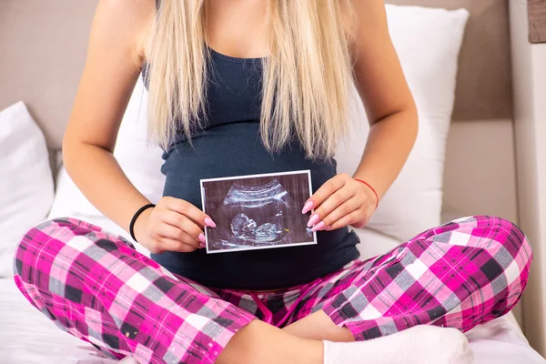 Šťastná mladá těhotná žena v posteli — Stock fotografie