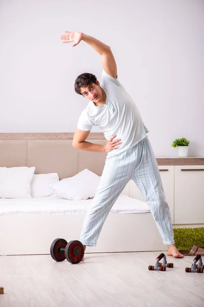 Genç adam yatak odasında sabah rutini yapıyor. — Stok fotoğraf
