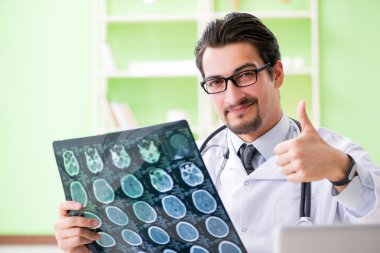 Doktor radyoloji uzmanı hastanede röntgen taramasına bakıyor.