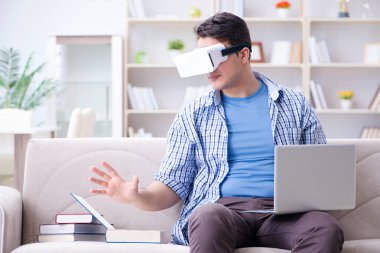 Evde sanal gerçeklik gözlükleriyle serbest çalışan bir öğrenci.