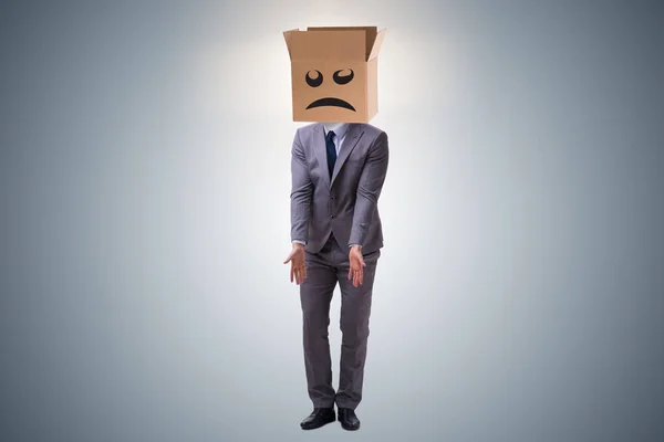 Businessman with box and unhappy face — Stock Photo, Image