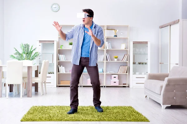Hombre con gafas de realidad virtual jugando en casa — Foto de Stock