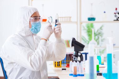 Laboratuvarda kimyasallar üzerinde çalışan genç bir kimyager.