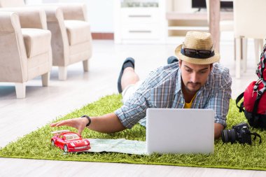 Genç adam internetten seyahat etmeyi planlıyor.