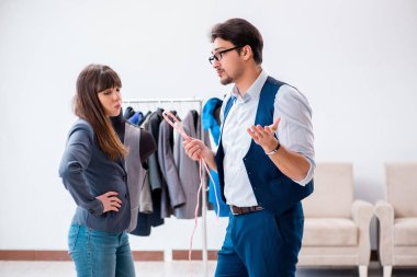 Profesyonel terzi resmi kıyafet için ölçü alıyor.