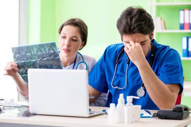 Kadın ve erkek jinekologlar Clini 'de tıbbi durumu tartışıyorlar.