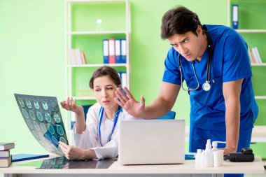 Kadın ve erkek doktorlar radyologlar klinikte çalışıyor. 