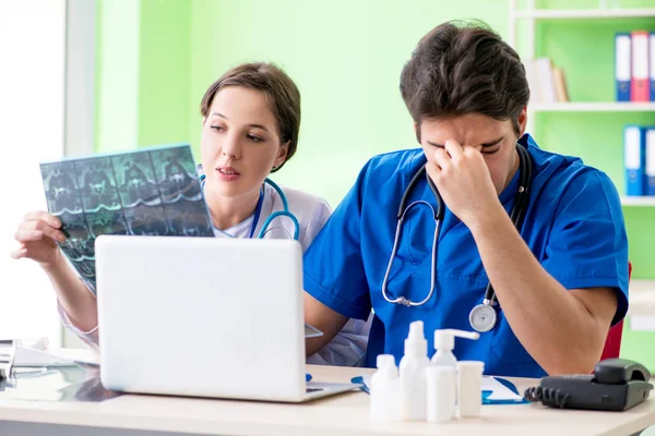 Kadın ve erkek jinekologlar Clini 'de tıbbi durumu tartışıyorlar.