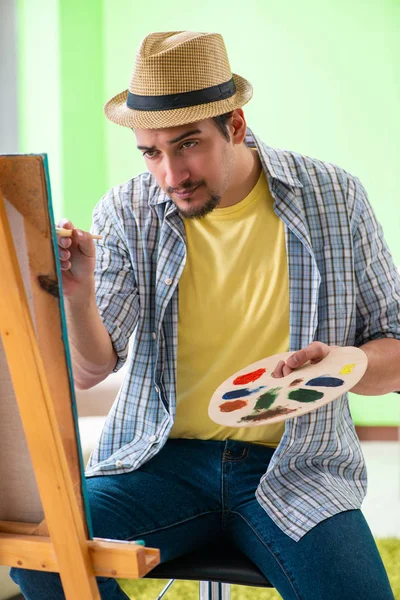 Jovem artista masculino trabalhando em nova pintura em seu estúdio — Fotografia de Stock