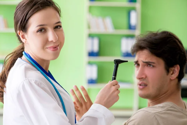 Médico femenino revisando pacientes oído durante examen médico —  Fotos de Stock