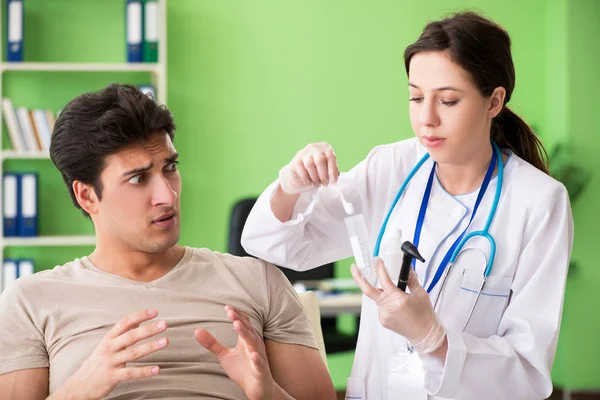 Médica verificando pacientes ouvido durante o exame médico — Fotografia de Stock