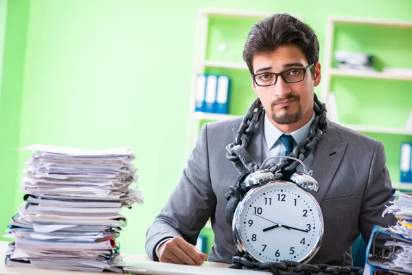 Empregado acorrentado à sua mesa devido à carga de trabalho — Fotografia de Stock