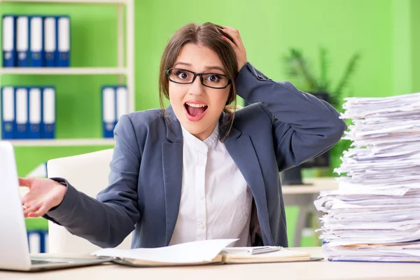 Junge Mitarbeiterin mit laufendem Papierkram beschäftigt — Stockfoto