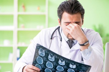 Doktor radyoloji uzmanı hastanede röntgen taramasına bakıyor.