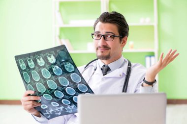 Doktor radyoloji uzmanı hastanede röntgen taramasına bakıyor.