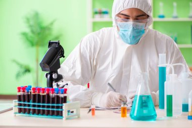 Laboratuvarda yeni bir deney üzerinde çalışan kimyager.