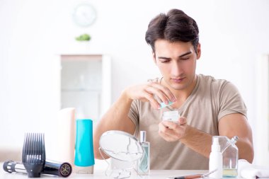 Genç yakışıklı adam aynaya bakıyor. 