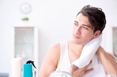 Genç yakışıklı adam aynaya bakıyor. 