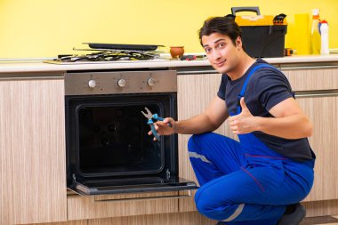 Genç müteahhit mutfak mobilyalarını monte ediyor.